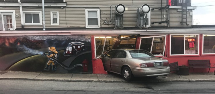 A car rests partly inside the Third Alarm Diner at 47 Washington St. in Sanford on Tuesday. Mark Nolet, 28, of Sanford was charged with driving without a license.