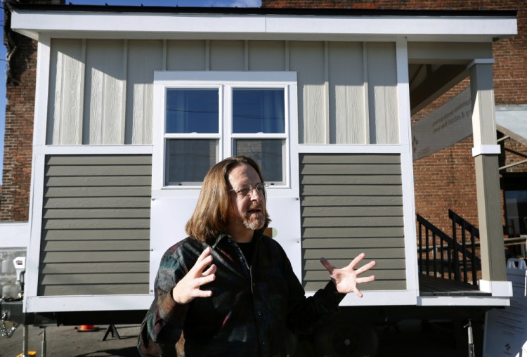 Joe Stevens stands in front of one of the tiny homes his student group built in hopes of helping the homeless in Des Moines, Iowa. "We're not giving up," he said.