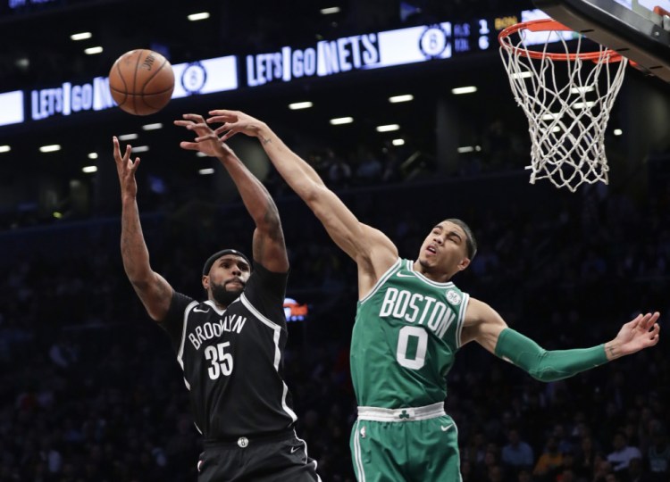 Boston's Jayson Tatum blocks a shot by Brooklyn's Trevor Booker during the Celtics' 109-102 win Tuesday in New York.