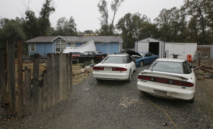 Cars are parked in front of the home of Kevin Janson Neal on Wednesday in Rancho Tehama Reserve, Calif. The body of Neal's wife was found at the home, where Neal started his shooting rampage that left four others dead, before he was shot and killed by Tehama County Sheriff's deputies.