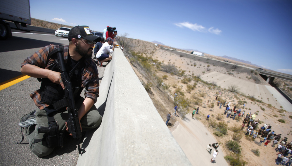 A Bundy supporter stands watch on a bridge in 2014 during a standoff between the Bundy family, their militia allies and the Bureau of Land Management near Bunkerville, Nev.