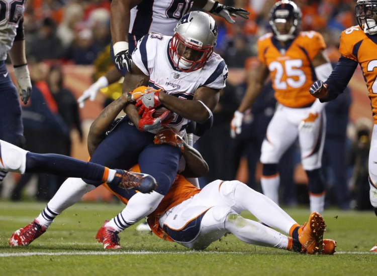 Dion Lewis breaks free of Denver strong safety Justin Simmons en route to a touchdown in the Patriots' 41-16 victory over the Broncos on Nov 16, 2017.