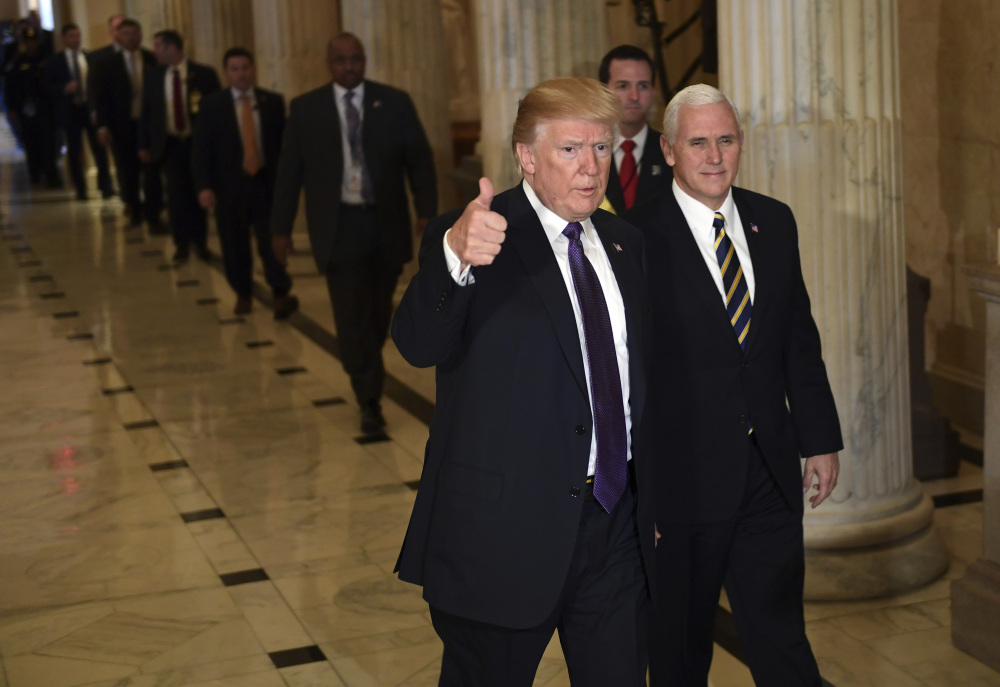 President Trump gives a thumbs up as he walks with Vice President Mike Pence as he departs Capitol Hill in Washington on Thursday. Across the Capitol, Democrats pointed to new numbers Friday showing the Senate version of the Republican tax plan would boost taxes on lower- and middle-income Americans.