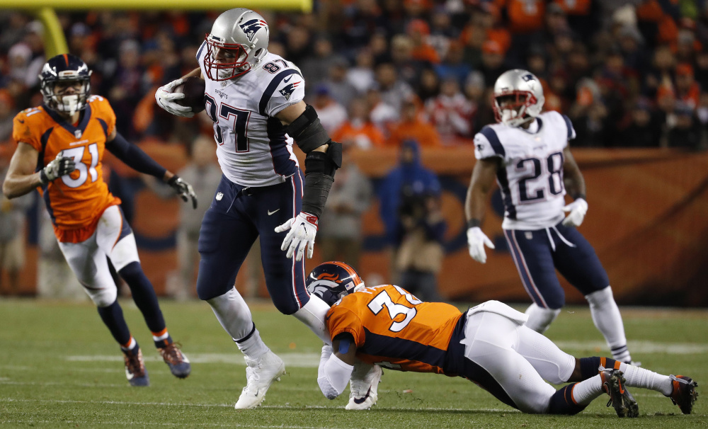 Patriots tight end Rob Gronkowski is hit by Broncos strong safety Justin Simmons during the second half of their game in Denver last Sunday. Gronkowski is likely to be covered by Raiders safety Obi Melifonwu, a second-round pick, on Sunday.