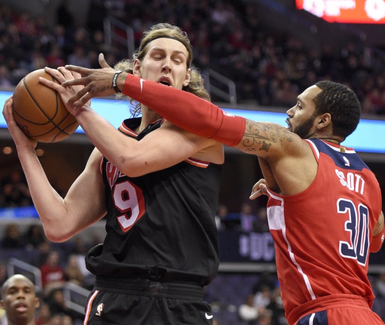 Kelly Olynyk of the Miami Heat attempts to keep the ball from Mike Scott of the Washington Wizards during the first half of the Heat's 91-88 victory Friday night at Washington. Miami saw a 25-point lead go down to one before holding on.