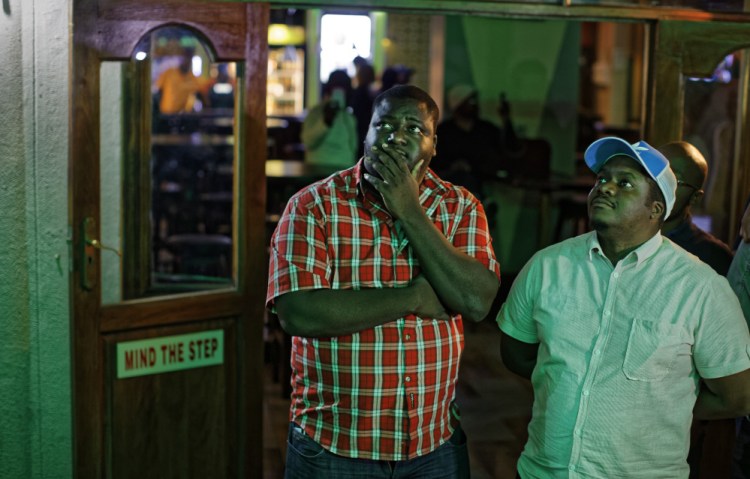 Disappointed Zimbabweans watch a televised address to the nation by President Robert Mugabe at a bar in downtown Harare on Sunday. Mugabe baffled the country by ending his address without announcing his resignation.