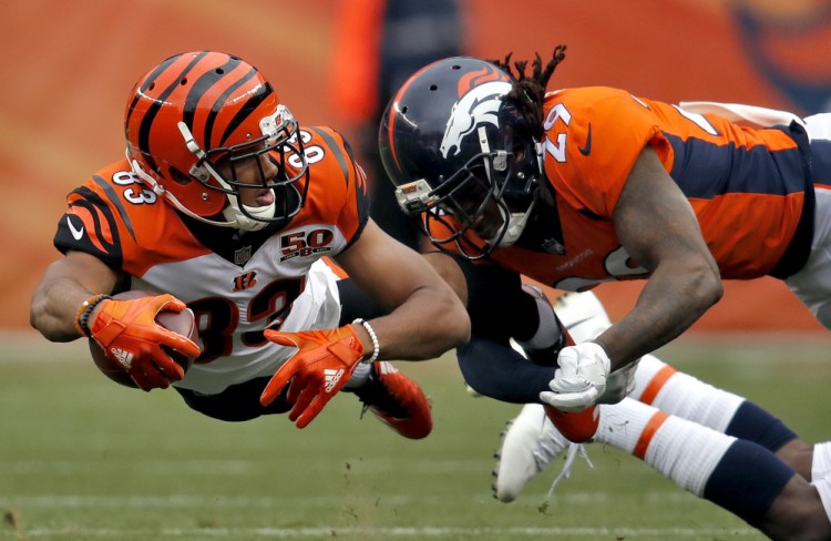 Bengals receiver Tyler Boyd lunges forward while being tackled by Denver's Bradley Roby. Cincinnati dealt the Broncos their sixth straight loss, 20-17.