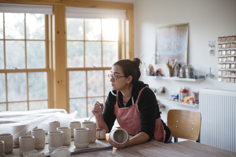 Ayumi Horie glazes new work in her studio in Portland. Horie is a ceramics artist who often uses her art to make statements and create dialogue about social and political issues.