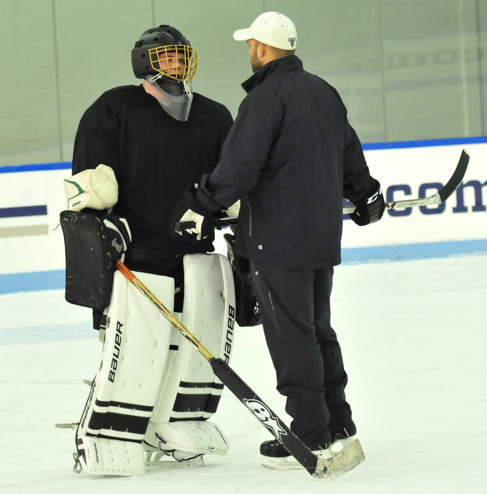 Kennebec RiverHawks coach Jon Hart instructs goalie Ben Grenier during practice Monday at Colby College.