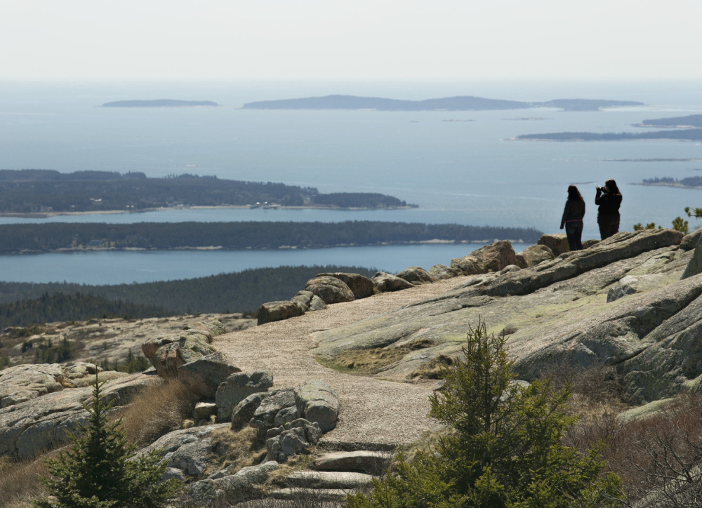 Two women take in the view from Cadillac Mountain in Acadia National Park. 
