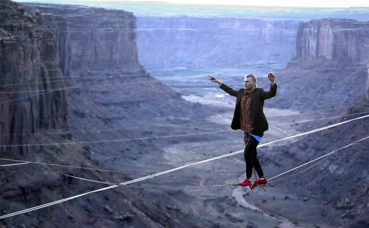 R.J. Roush slacklines across the Fruit Bowl this week near Moab, Utah, site of an extreme sports event called the GGBY. Participants walk across lines of webbing stretched between rock crevices or jump from sandstone mesas.