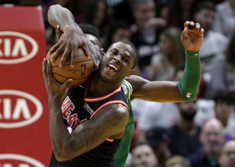 Miami's Dion Waiters fights for the ball with Boston's Jaylen Brown in the first half Wednesday in Miami.