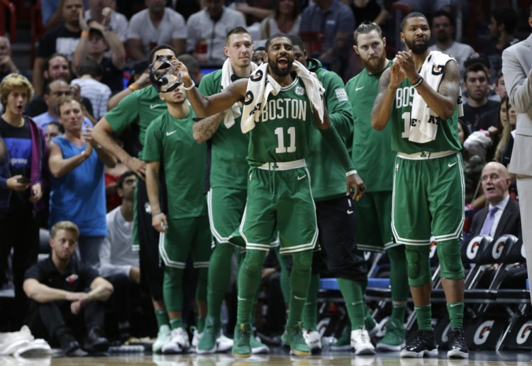 Kyrie Irving of the Celtics watches with teammates during the second half of their loss to the Heat in Miami on Wednesday night. Irving says scoring achievements can't compare to being on an 'unbelievable team.'