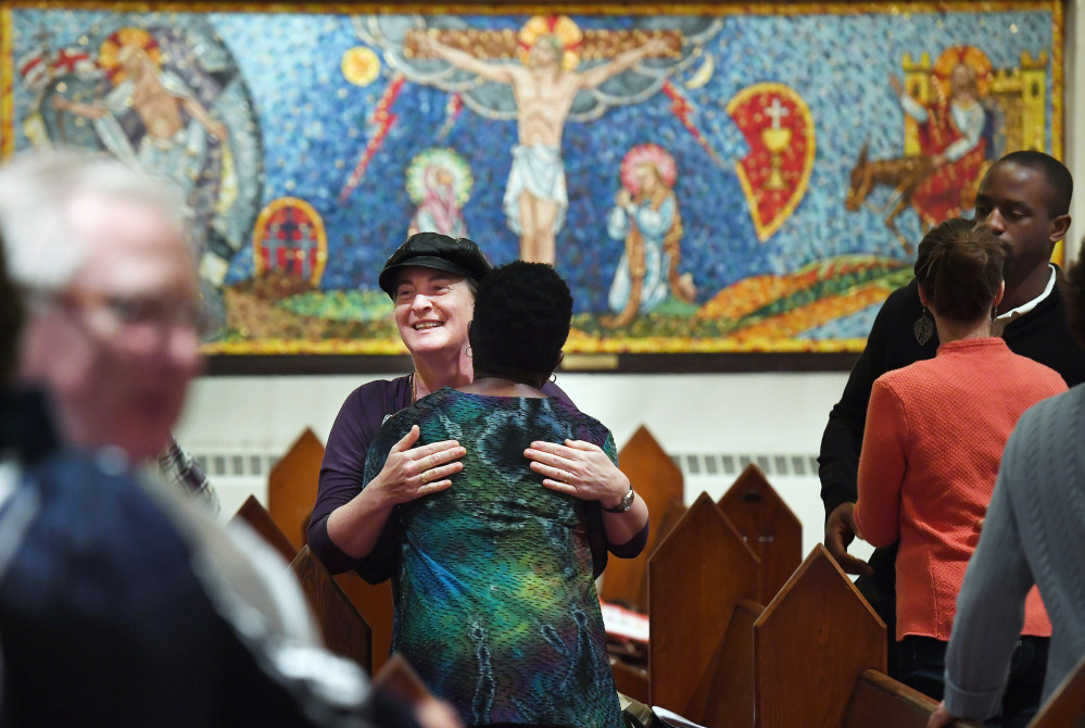Isabelle Melese-d'Hospital, facing the camera, embraces Charleen Ward during a service at St. Margaret's Episcopal Church in Washington, D.C. "I needed to have that family support of the church" after the 2016 election, Ward said.