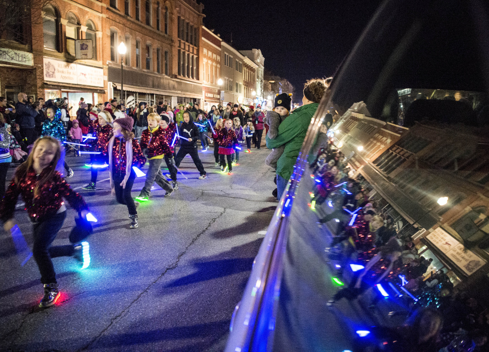 Participants in the annual Parade of Lights march down Main Street on Friday in downtown Waterville.