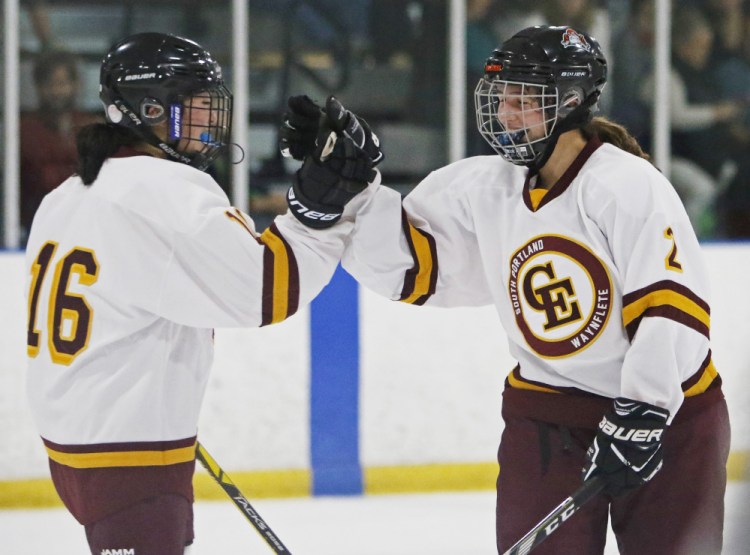 Koto Yamada, left, and Nicoletta Coupe celebrate Coupe's goal in the second period Saturday that helped Cape Elizabeth to a 12-2 victory against Gorham in a girls' hockey opener at Troubh Arena.