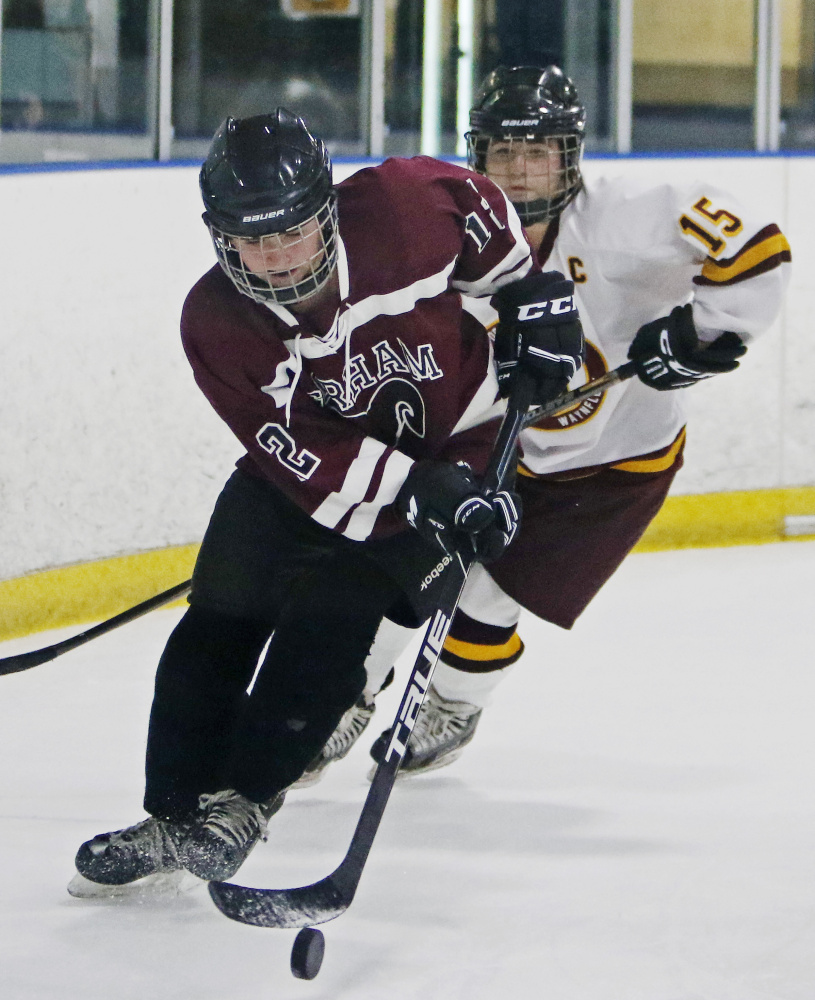 Megan Polchies of Gorham handles the puck behind the net while Erika Miller of Cape Elizabeth pursues during the second period in Portland.