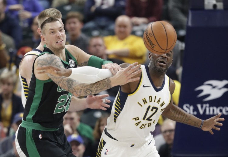 Daniel Theis, left, of the Boston Celtics battles with Damien Wilkins of the Indiana Pacers for a loose ball during the first half of Saturday;s game in Indianapolis. The Celtics held a 37-16 scoring advantage in the third period and went on to a 108-98 win.