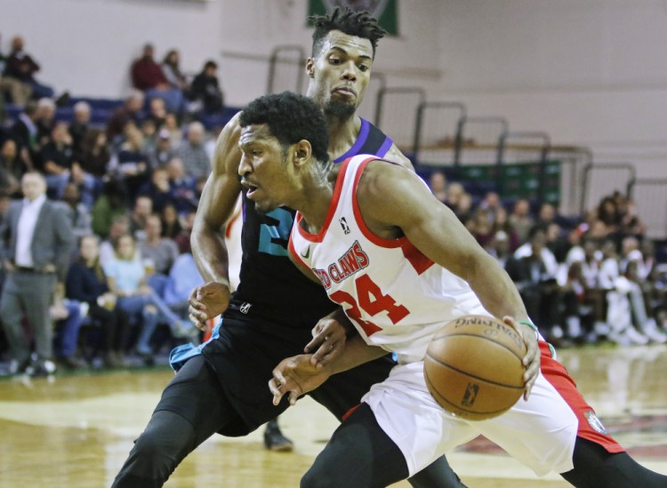 Maine's Andrew White drives around Greensboro's Charles Cooke in third quarter of the Red Claws' 135-111 win Sunday at the Portland Expo.