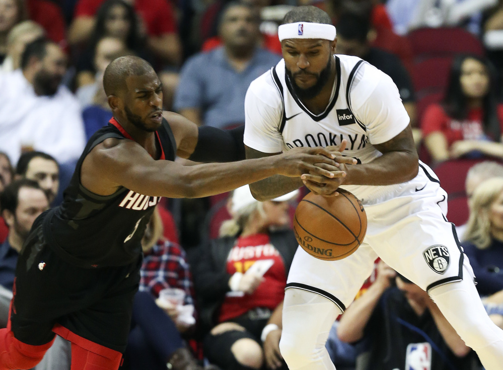 Rockets guard Chris Paul, left, steals the ball from Brooklyn Nets forward Trevor Booker in the first half of Houston's 117-103 win at home Monday night. Paul had 14 assists.