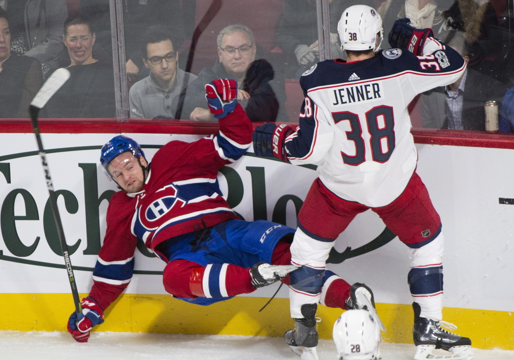 Montreal's Jakub Jerabek is checked into the boards by Columbus' Boone Jenner during first period of the Canadiens' 3-1 win Monday in Montreal.