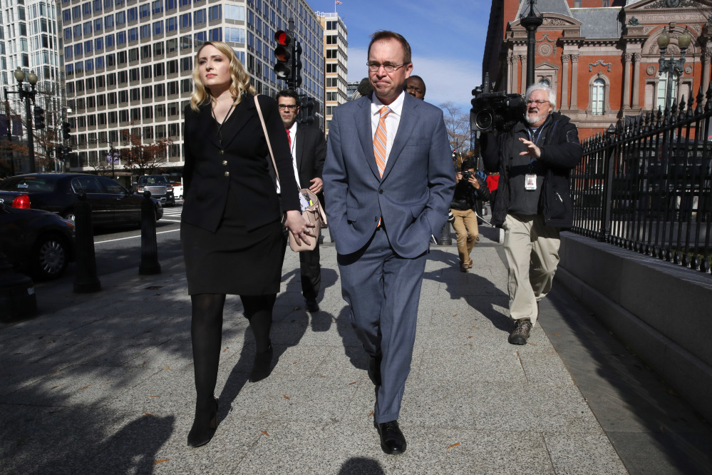 Mick Mulvaney walks to the Eisenhower Executive Office Building after leaving the Consumer Financial Protection Bureau  Monday. The judge's ruling letting him keep the acting director's position is not the final decision.