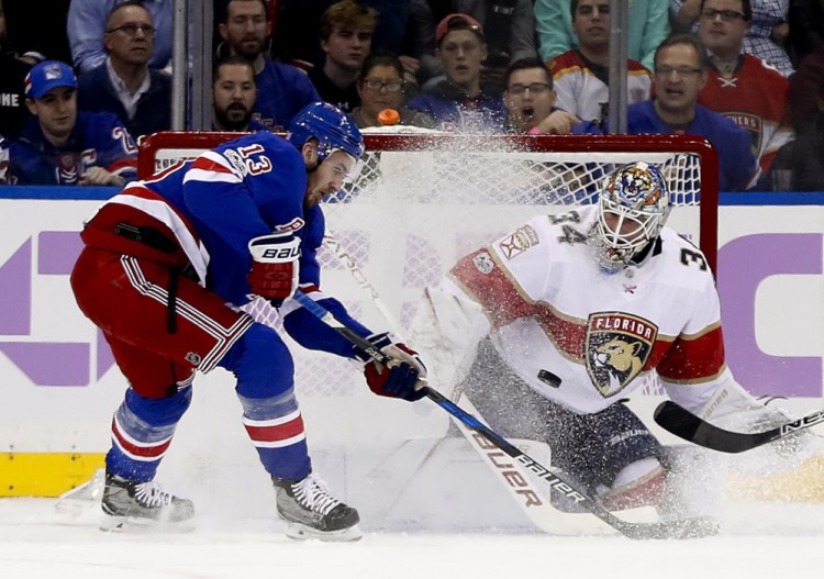 Panthers goalie James Reimer blocks a shot as Kevin Hayes of the Rangers looks for a rebound in the first period Tuesday night in New York. The Panthers scored late in the third period for a 5-4 win.