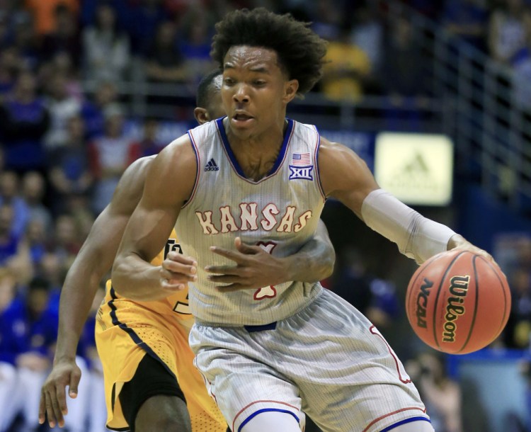 Devonte' Graham of Kansas is hampered by Marreon Jackson of Toledo during the first half Tuesday night. No foul was called on the play. Kansas won, 96-58.