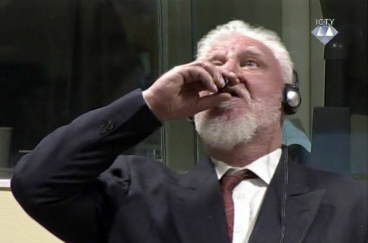 Slobodan Praljak brings a bottle to his lips during a Yugoslav War Crimes Tribunal in The Hague, Netherlands. Praljak yelled, "I am not a war criminal!" and appeared to drink from a small bottle, seconds after judges reconfirmed his 20-year prison sentence for involvement in a campaign to drive Muslims out of a would-be Bosnian Croat ministate in Bosnia in the early 1990s.
