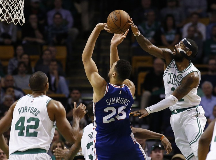 Boston's Kyrie Irving blocks a shot by Philadelphia's Ben Simmons in the fourth quarter Thursday night in Boston.