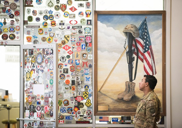 Senior Airman Perry Lopez of McChord Air Force Base in Washington state looks at the memorabilia left by traveling servicemen and women at the Maine Troop Greeters room at the Bangor International Airport.More than 1.5 million troops have passed through Bangor on military flights to and from Iraq, Afghanistan and other overseas destinations.