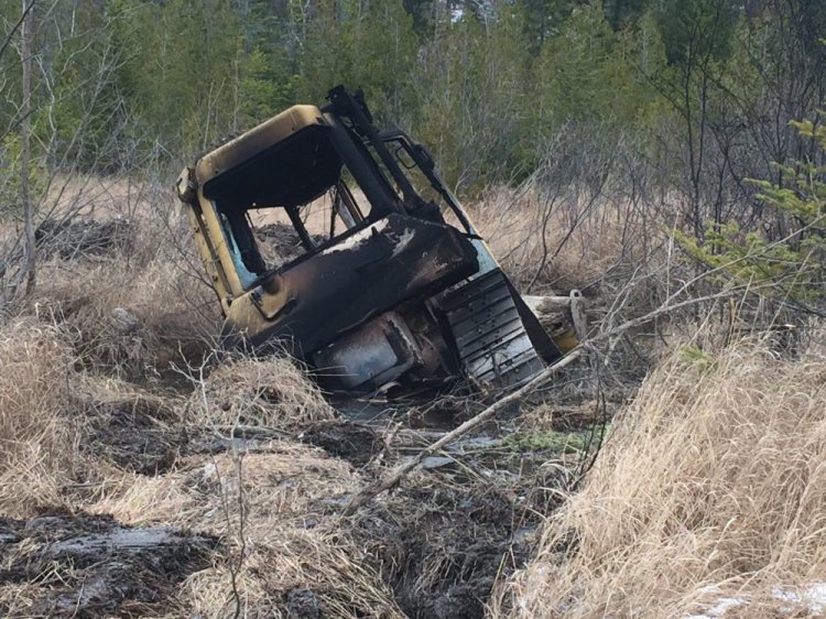 This bulldozer, owned by Cousineau Wood Products of Wilton, was found by hunters on Tuesday off Beech Hill Road in Sandy River Plantation, where it had been set on fire.