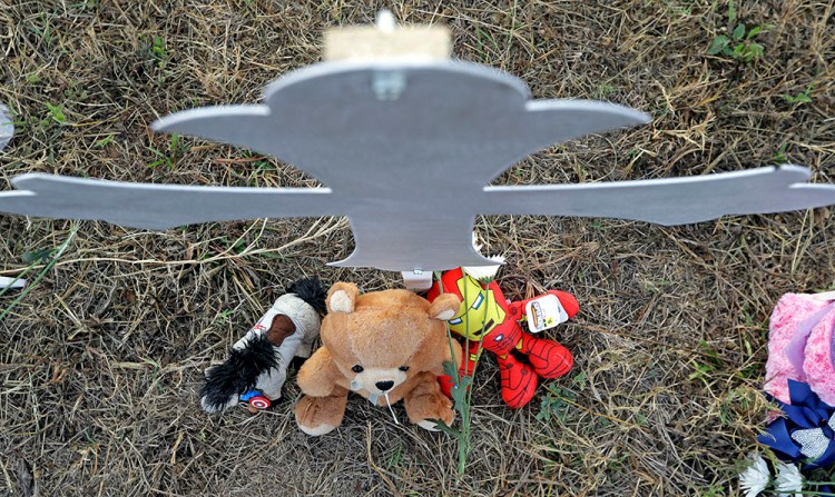 Stuffed animals rest at the base of a cross at a makeshift memorial for victims near the scene of a shooting at the First Baptist Church of Sutherland Springs, Tuesday.