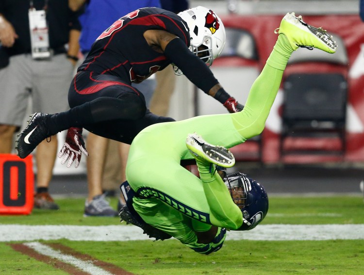 Seattle Seahawks wide receiver Paul Richardson makes the catch as Arizona Cardinals safety Budda Baker, left, defends in the first half Thursday night in Glendale, Ariz.
