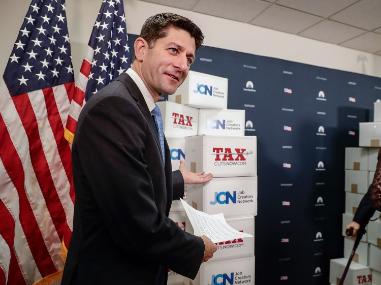 Speaker of the House Paul Ryan, R-Wis., points to boxes of petitions supporting the Republican tax reform bill that is set for a vote later this week as he arrives for a news conference on Capitol Hill in Washington, Tuesday.