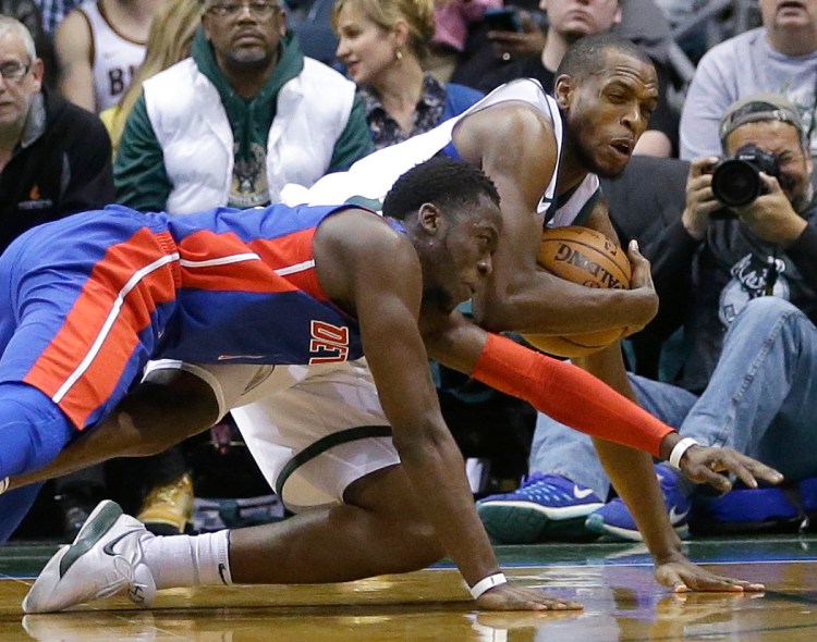 Milwaukee's Khris Middleton, top, vies for a loose ball with Detroit's Reggie Jackson in the second half Wednesday night.