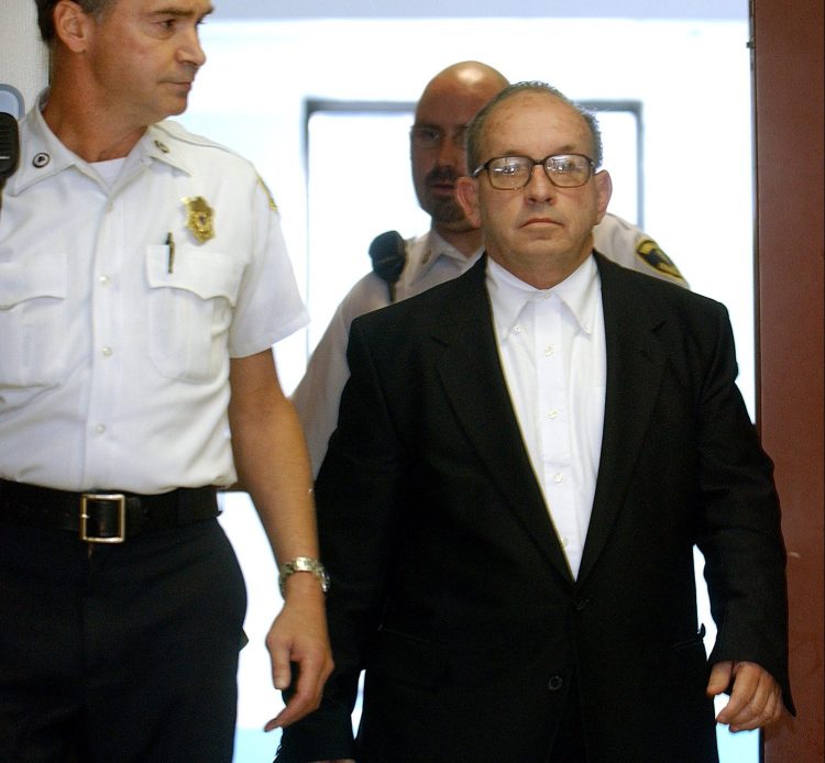 James Talbot, a Jesuit priest at the time, is escorted into Suffolk Superior Court in Boston on Sept. 19, 2002, for arraignment on charges of rape, and indecent assault and battery.