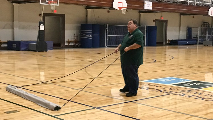 Jim Gauthier pulls a wet-dry mop over the gym floor Wednesday morning at the Lewiston Recreation Center. Employees were cleaning up Wednesday after someone broke in overnight and created a mess.