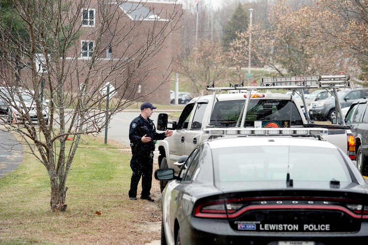 Community Resource Officer Charlie Weaver of the Lewiston Police Department talks with a motorist about the lockdown at Lewiston High School on Monday.
