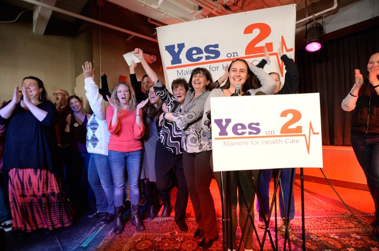 Jennie Pirkl, campaign manager for Mainers for Health Care, at the microphone, is joined by other supporters of state ballot Question 2, the expansion of Medicaid in Maine, as they celebrate their apparent victory at the polls on Election Day at Bayside Bowl in Portland.