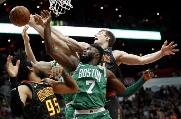 Boston Celtics' Jaylen Brown reaches for a rebound with teammate Aron Baynes, rear, against Hawks' Tyler Cavanaugh, right, and DeAndre' Bembry in the first quarter in Atlanta on Saturday. 