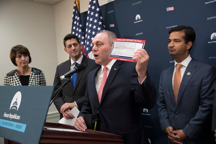 House Majority Whip Steve Scalise, R-La., joined by, from left, Rep. Cathy McMorris Rodgers, R-Wash., Speaker of the House Paul Ryan, R-Wis., and Rep. Carlos Curbelo, R-Fla., a member of the House Ways and Means Committee, holds up a proposed postcard-sized tax form as they talk about the Republican agenda for tax reform, during a news conference on Capitol Hill on Oct. 24.