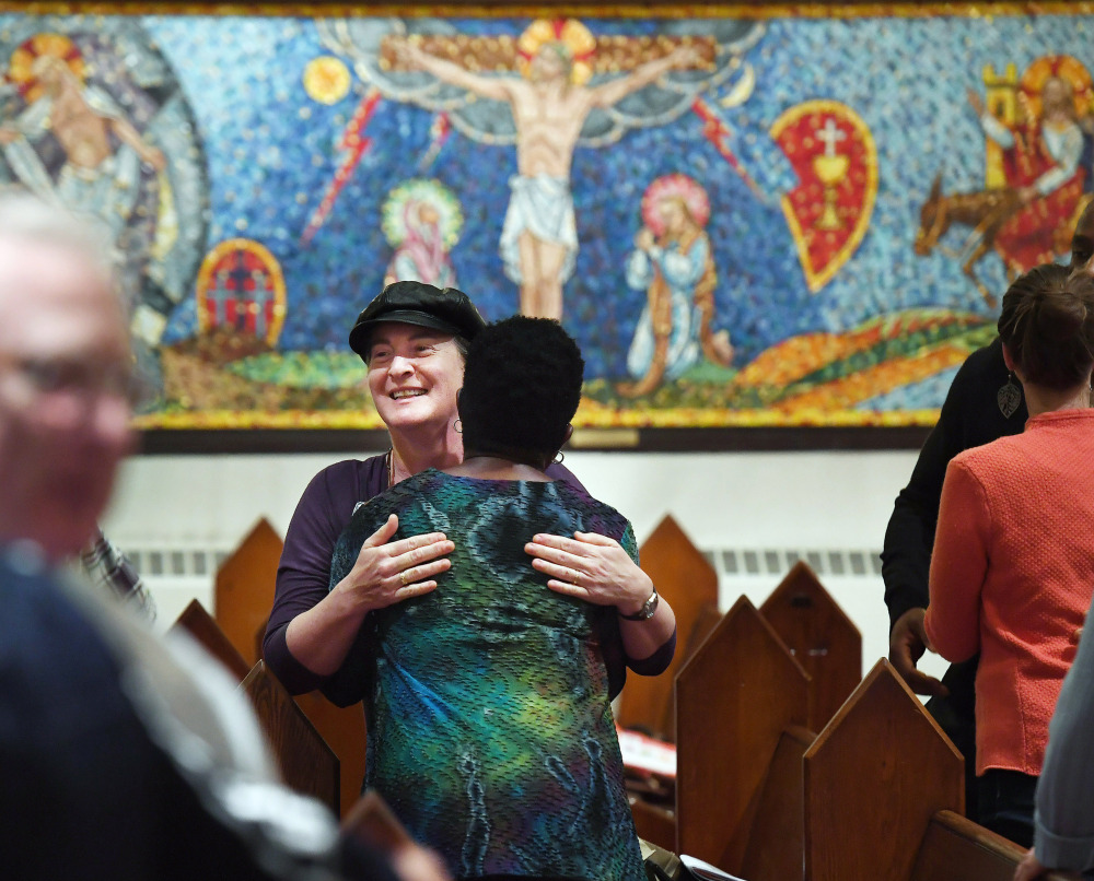 Isabelle Melese-d'Hospital, facing the camera at center, embraces Charleen Ward during a service at St. Margaret's Episcopal Church in the District of Columbia. "I needed to come after the (2016) election. ... I needed to have that family support of the church," Ward said.