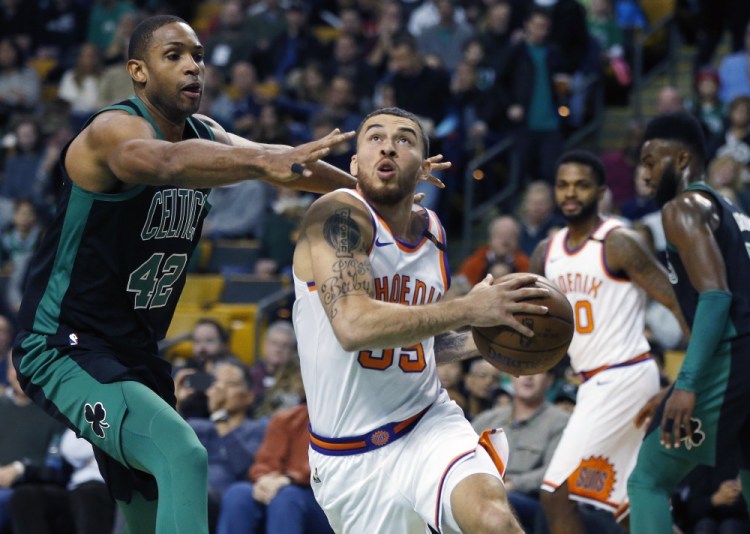 Mike James of the Suns drives past Al Horford of the Celtics during the first quarter Saturday in Boston. The Celtics held on for a 116-111 win.