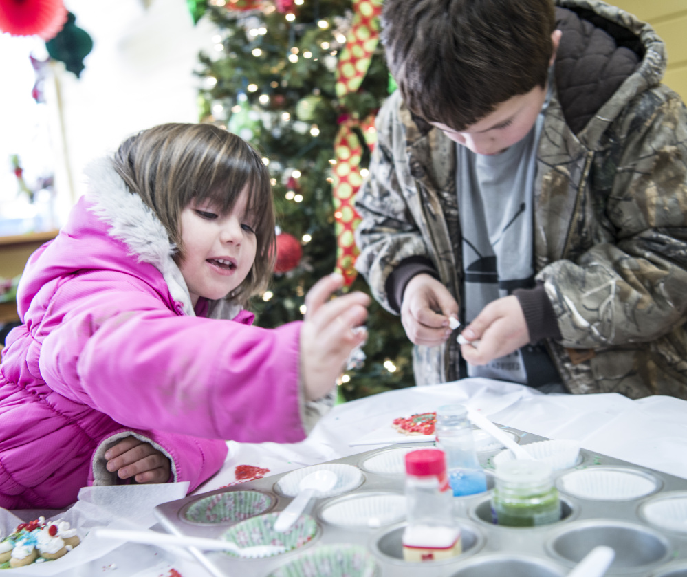 Hannah Veilleux, 4, makes holiday cookies Saturday with her brother, Isaiah Vear, 11, at Holy Cannoli in Waterville. The event was part of the city's Joy to the Ville activities.