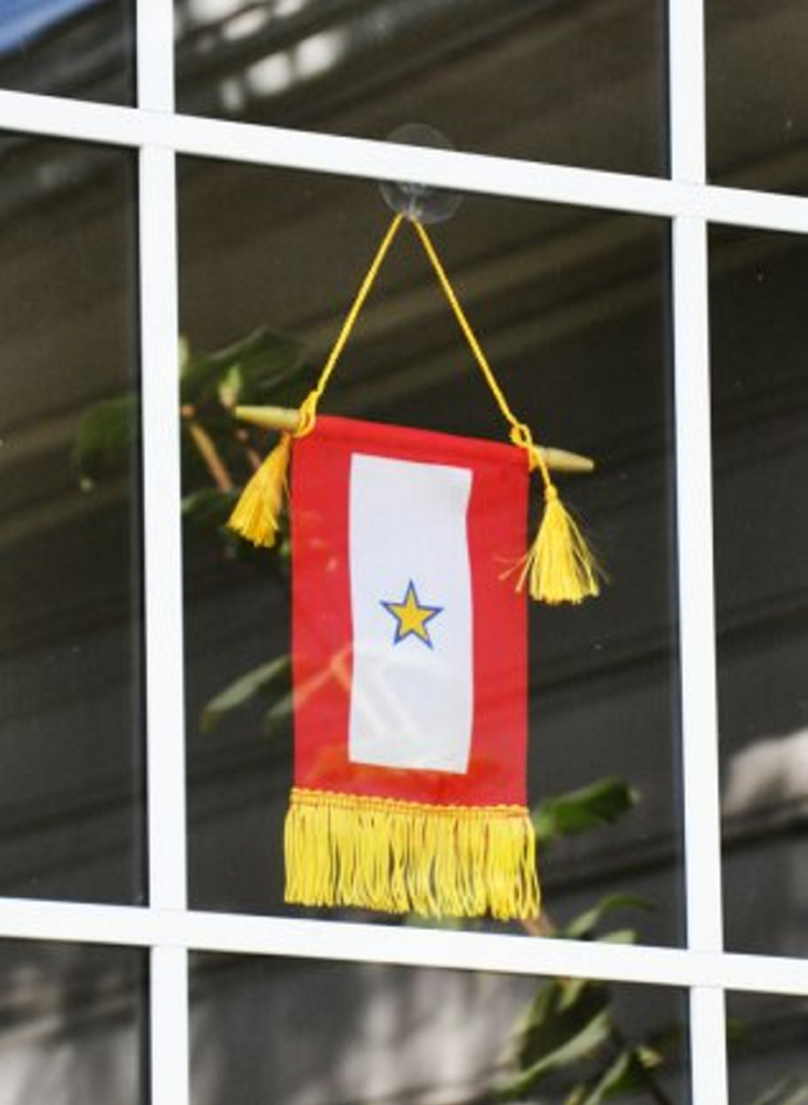 Displaying a Service Flag with a blue star covered by a gold star signifies that a family member died while serving in the armed forces. A Gold Star is only realized through years of absence.