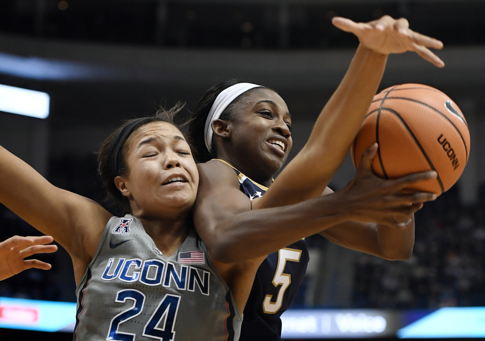 Napheesa Collier of Connecticut tangles with Jackie Young of Notre Dame while competing for a rebound Sunday during top-ranked UConn's 80-71 victory over the third-ranked Fighting Irish at Hartford, Conn.