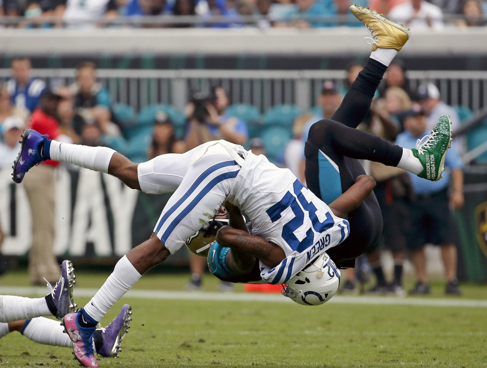 Jaguars tight end Marcedes Lewis, back, is tackled Sunday by Colts safety T.J. Green during Jacksonville's 30-10 win that kept the Jaguars tied with Tennessee atop the AFC South.