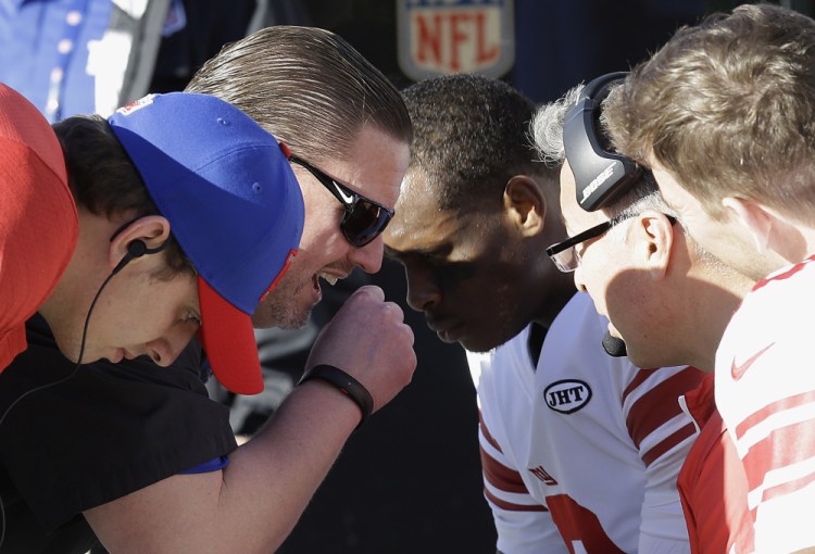 Giants coach Ben McAdoo talks with quarterback Geno Smith, center, Eli Manning, right, and Davis Webb, left, during the first half against the Raiders in Oakland, Calif. on Sunday.