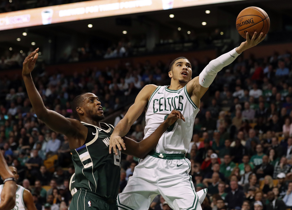 The Celtics' Jayson Tatum goes to the basket past the Bucks' Khris Middleton in the second quarter of Monday night's home win by the Celtics.